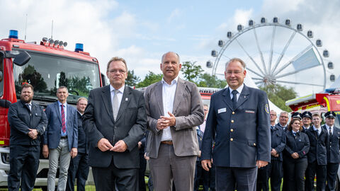 Landrat Becker, Innenminister Roman Poseck und Präsident des Landesfeuerwehrverbands Norbert Fischer Landrat Becker, Innenminister Roman Poseck und Präsident des Landesfeuerwehrverbands Norbert Fischer stehen vor einem Feuerwehrauto und schauen in die Kamera