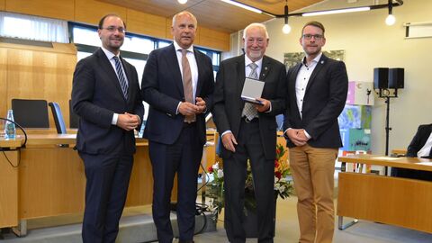 Kommunalminister Roman Poseck bei der Übergabe der Freiherr-vom-Stein-Plakette an Karl-Heinz Stier  Vier Männer stehen in einem Raum nebeneinander.